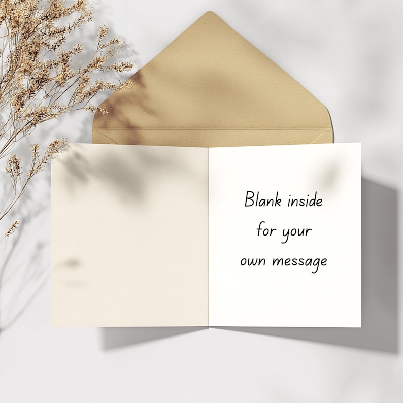 Puede incluir: Una tarjeta de felicitaci&oacute;n abierta con un interior en blanco, acompa&ntilde;ada de un sobre marr&oacute;n. El lado derecho de la tarjeta presenta el texto "Blank inside for your own message" en escritura negra. Elementos florales secos son visibles.