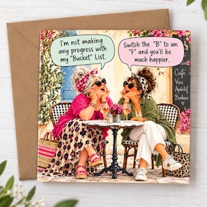 May include: A square greeting card featuring two women sitting at a cafe table with wine glasses. One says, I'm not making any progress with my Bucket List. The other replies, Switch the B to an F and you'll be much happier. They wear headscarves, sunglasses, and casual clothing.