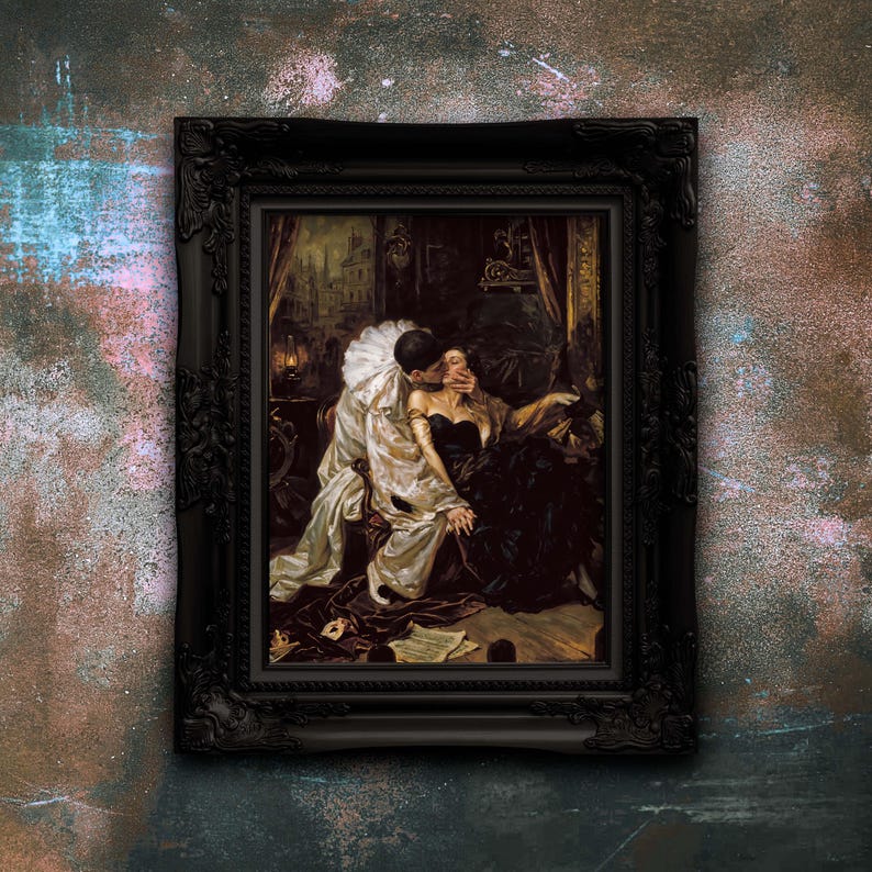 May include: A framed print featuring a painting of a person in a white ruffled collar costume embracing another person in a dark gown. The artwork is enclosed in a decorative black frame with ornate carved details along the edges and corners.