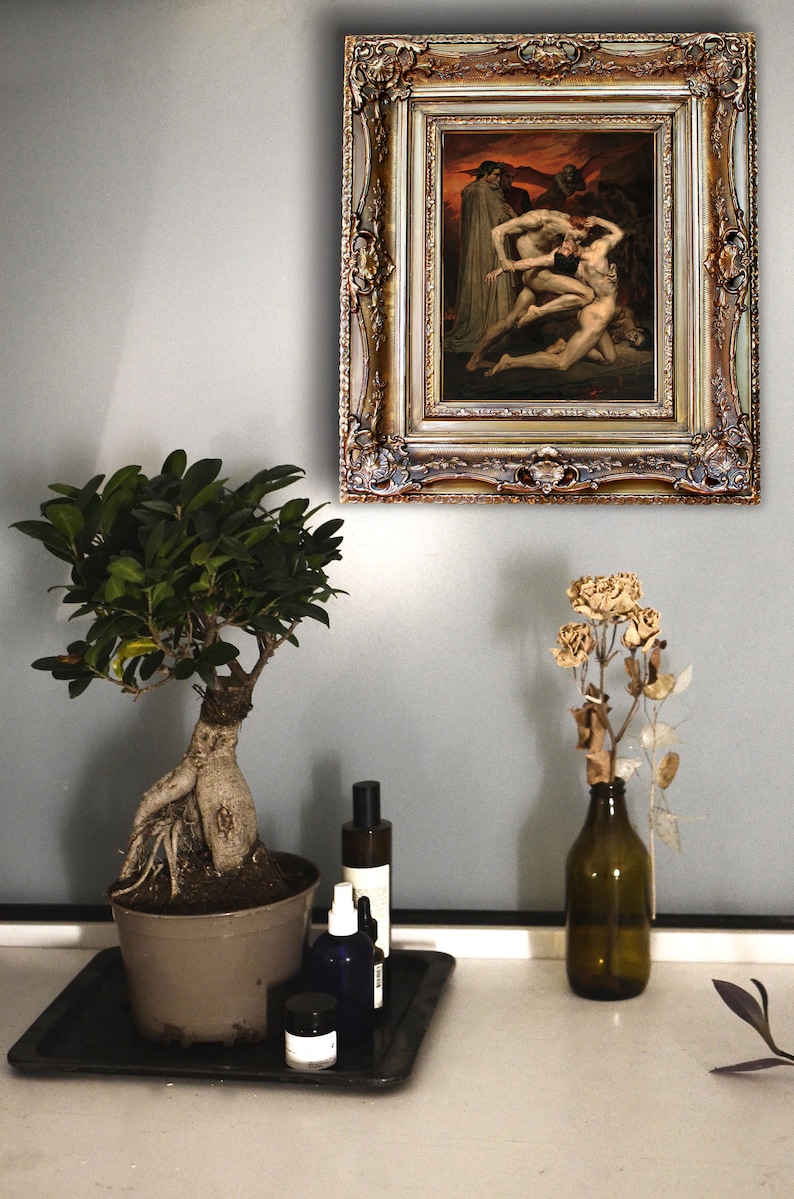 May include: A framed painting of a dramatic scene with three figures in a dark, fiery setting. The painting is in a gold ornate frame and is hanging on a light gray wall.