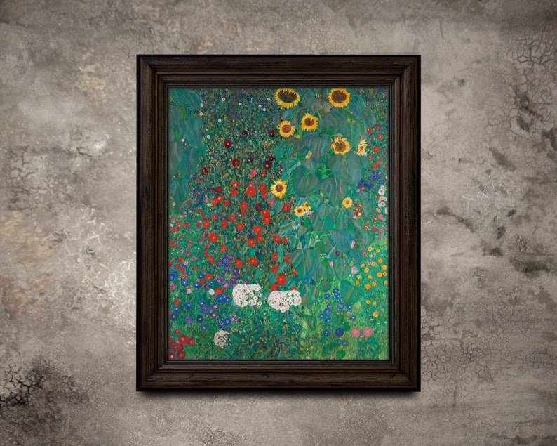 May include: Framed art print of a colorful garden scene with sunflowers, red, white, and blue flowers. The artwork is in a dark brown wooden frame and hangs on a textured gray wall. The painting has a vibrant, impressionistic style.