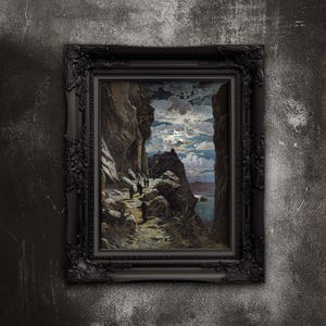 May include: A framed landscape painting depicting a coastal path with figures walking towards a distant structure. The artwork features a dramatic sky with clouds and a moon, set within a black ornate frame. The painting is mounted on a textured, dark gray wall.