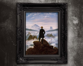 May include: A framed print of a Romantic landscape painting. The artwork depicts a figure standing on a rocky outcrop, gazing at a misty mountain range. The frame is black with ornate detailing, set against a textured gray background.