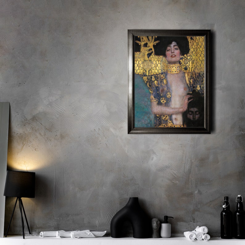 May include: A framed painting of a woman with long dark hair wearing a gold and blue patterned robe. The woman is looking to the left and has a serious expression. The painting is set against a gray wall.
