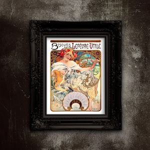 May include: Framed vintage advertisement for "Biscuits Lefèvre-Utile" featuring a woman in a flowing white dress holding a plate of biscuits. The artwork is in the Art Nouveau style, with floral and ornate details, set in a black ornate frame.