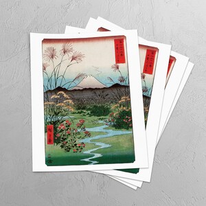 May include: A set of five prints featuring a Japanese landscape with Mount Fuji in the background. The prints are in a traditional Japanese style with a blue sky, green hills, and a winding river. The prints are framed in white and have a red border.