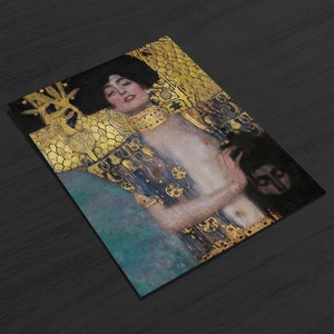 May include: A painting of a woman with long dark hair, wearing a gold and blue robe. She is holding a small figure in her hand. The background is a gold and blue pattern.