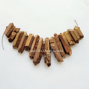 May include: A strand of gold-toned crystal point beads, arranged in a V-shape. The beads are hollow and have a rough, natural texture.  "Autumn Hollow Beads" is written in white text on the image.