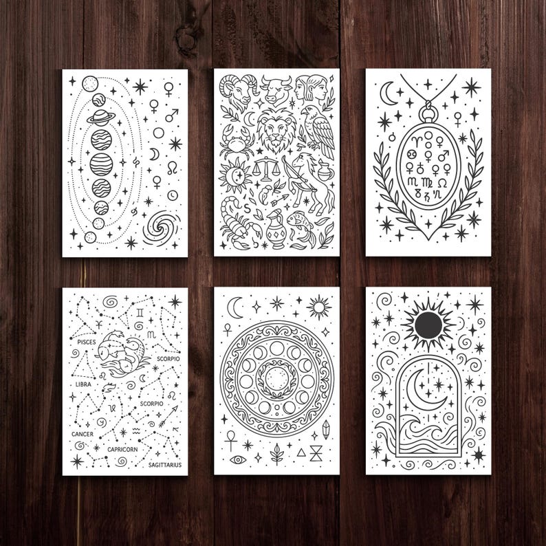 May include: Six white rectangular cards with black line art illustrations of celestial and astrological themes. The cards feature planets, constellations, zodiac symbols, and decorative elements. The cards are arranged on a dark wood surface.