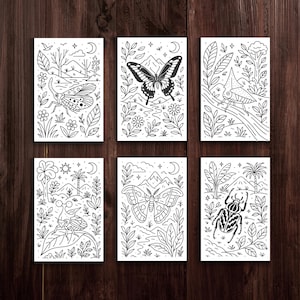 Op de afbeelding: Zes zwart-wit kunstprints met gedetailleerde illustraties van insecten en natuursc&egrave;nes. Elke print toont een ander insect, waaronder een vlinder, een mot en een kever, omringd door bladeren, bergen en hemelse elementen. De prints zijn gerangschikt op een donker houten oppervlak.