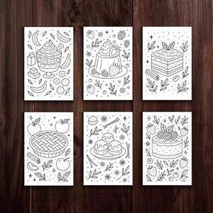 May include: Six black and white illustrated cards featuring desserts. The cards depict a sundae, a jelly dessert with berries, a layered cake, an apple pie, cream puffs, and a cake with berries. The illustrations are surrounded by decorative elements.