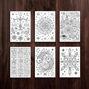 May include: Six black and white tarot card prints with celestial and astrological designs. The cards depict symbols like scales, a compass rose, a telescope, and koi fish. The bottom left card displays tarot card names like "The Empress" and "The Lovers".