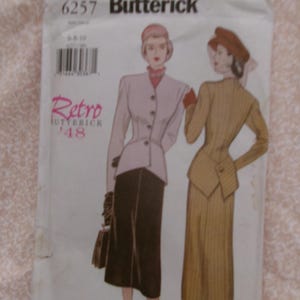 May include: A vintage Butterick sewing pattern packet featuring illustrations of women's retro fashion designs. The packet is white with the text "6257 Butterick" and "Retro '48" in pink. The illustrations depict a skirt suit and a dress.