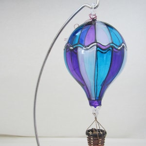 Adorno de globo aerostático de vidrio soplado y pintado a mano en colores morado, turquesa y blanco.