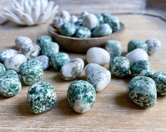 May include: A collection of green and white tumbled stones. The stones are smooth and polished, with a variety of patterns and textures.