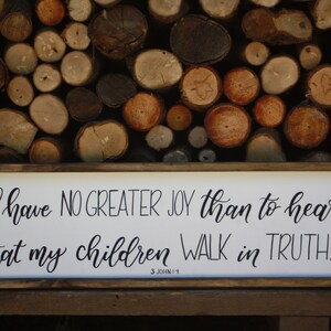 Puede incluir: Un letrero de madera con fondo blanco y letras negras. El letrero dice "I have NO GREATER JOY than to hear that my children WALK in TRUTH. 3 JOHN 1-4".