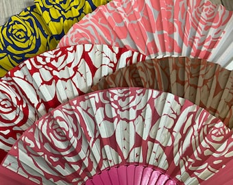 May include: A set of four folding fans with a rose pattern. The fans are in various colors, including red, pink, brown, and yellow. The fans are made of paper and have a wooden handle.