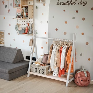 Grey wooden coat rack placed next to a wooden TOYS container, helping families organize entryway clutter before holiday guests arrive.