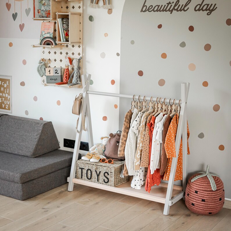 Grey wooden coat rack placed next to a wooden TOYS container, helping families organize entryway clutter before holiday guests arrive.