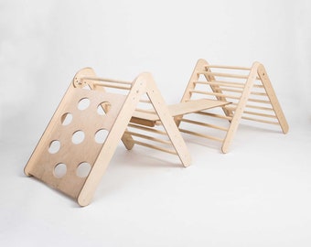May include: A wooden climbing frame for children, featuring a slide, a ladder, and a bridge. The frame is made of natural wood and has a light brown finish.