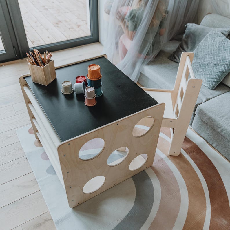 Top angle view of a black chalkboard surface convertible table with a toddler seat.