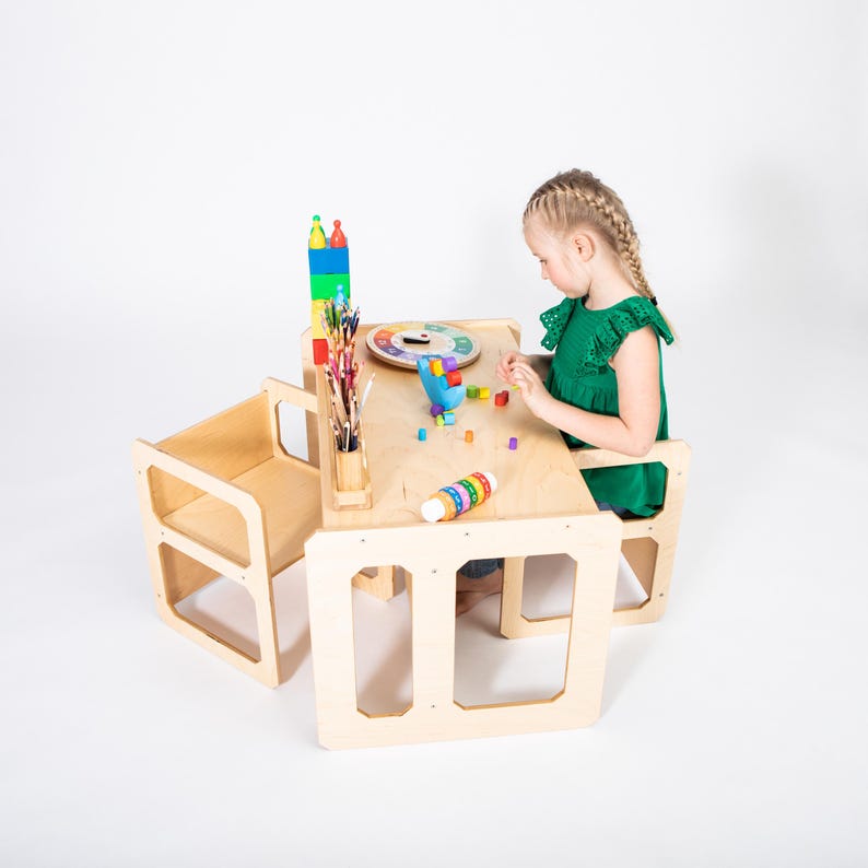 Young girl playing with wooden educational toys at a natural birch plywood weaning table set.