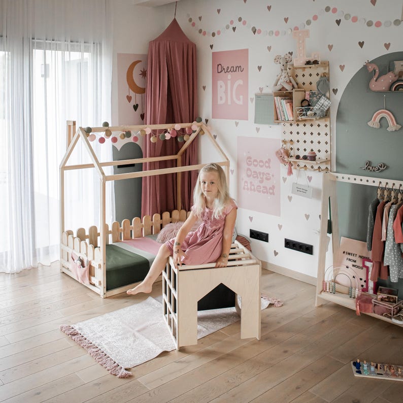 Young girl sitting by an activity desk in a spacious nursery setting.