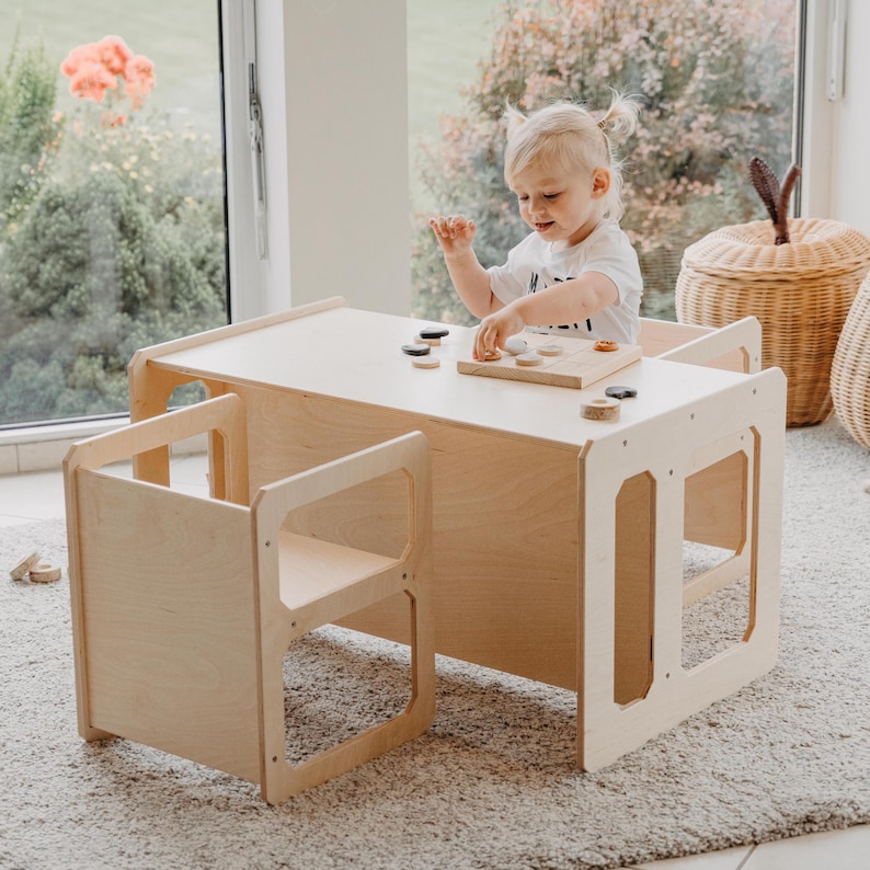 Natural color toddler play desk and cube chair set placed in a bright playroom.