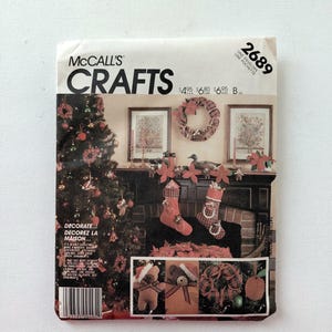 May include: A McCall's Crafts sewing pattern envelope, number 2689, featuring a Christmas-themed display with a decorated tree, stockings, and a wreath. The cover shows images of teddy bears and ornaments, with text including 'McCall's Crafts' and 'Decorate'.