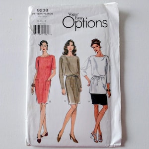 May include: Vogue Easy Options sewing pattern packet. The packet features illustrations of three different dress designs. The front of the packet is white with the Vogue logo and pattern number 9238. The dress designs are in shades of red, tan, and white and black.
