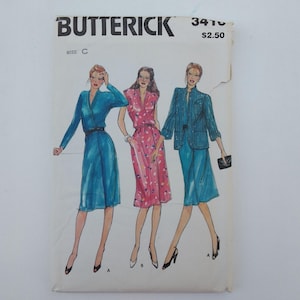 May include: A vintage Butterick sewing pattern envelope featuring illustrations of three different dress designs. The designs include a blue wrap dress, a pink floral dress, and a blue suit. The envelope has the text "Butterick" and "3410".