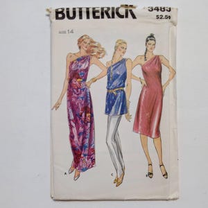 May include: Vintage sewing pattern for a one-shoulder dress. The pattern is for size 14 and includes three different styles. The pattern is from Butterick and the pattern number is 3483.