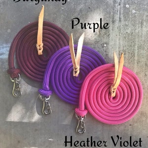 May include: Three coiled ropes with leather ends and metal clasps. The ropes are burgundy, purple, and heather violet.