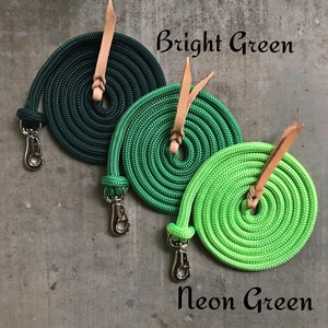 May include: Three coiled ropes in different shades of green, hunter green, bright green, and neon green. Each rope has a brown leather loop and a silver clip.