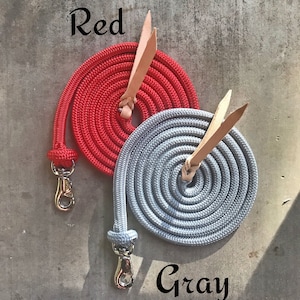 May include: Two coiled ropes with leather handles and metal clasps. One rope is red and the other is grey. The text "Red" is above the red rope and the text "Gray" is below the grey rope.