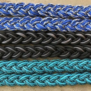 May include: Four different braided ropes in blue, gray, black, and turquoise. The ropes are all braided in a similar pattern and are all about the same thickness.