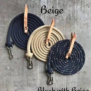 Op de afbeelding: Drie opgerolde touwen met leren uiteinden en metalen sluitingen. De touwen zijn zwart, beige en zwart met beige stippen. De touwen zijn gelabeld met "Zwart", "Beige" en "Zwart met Beige".