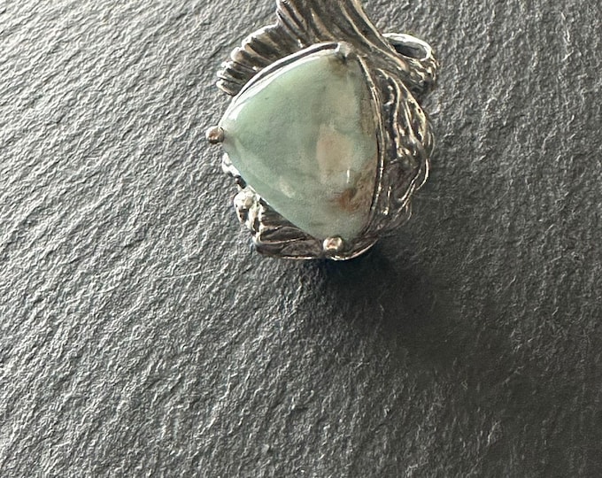 Solid silver ring with a sleeping mermaid around a natural larimar center stone