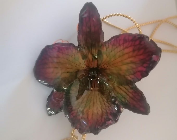Lucky purple orchid necklace with green and turquoise reflections embedded in resin and finished with gold on bronze adjustable clasp.