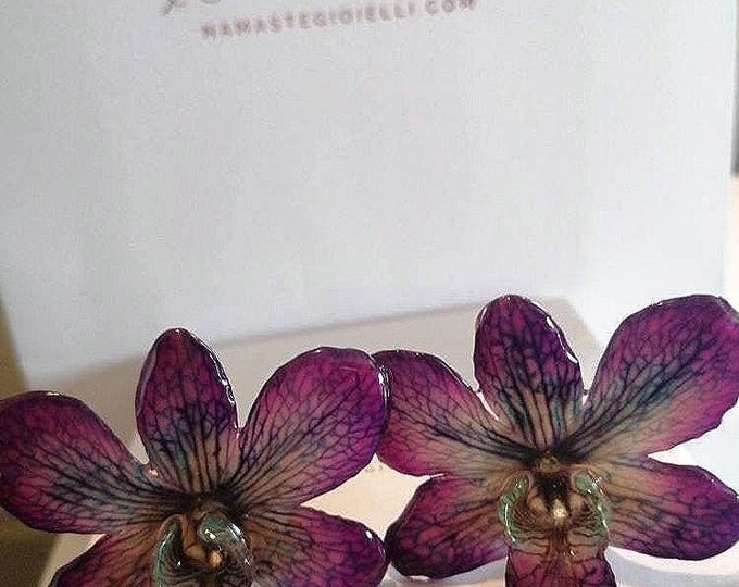 Pair of purple Dendrobium orchids with turquoise and green veins embedded in resin with silver hooks