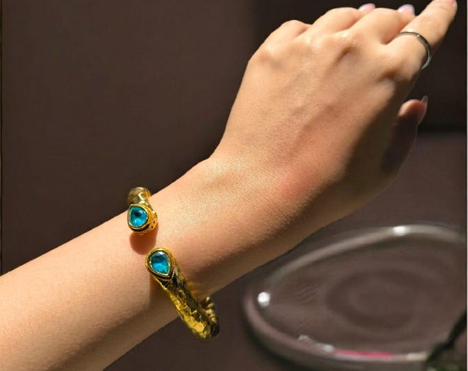 spectacular Etruscan spring bracelet in matte gold on bronze and finished with natural faceted blue topazes.