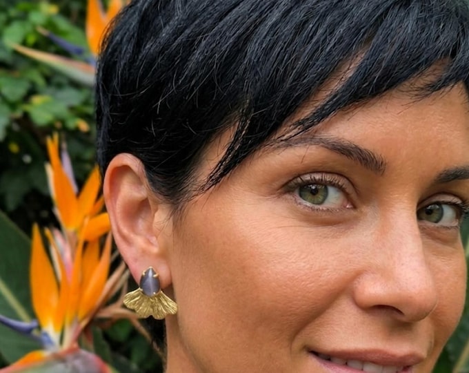 Gold-on-bronze stud earrings finished with natural faceted purple cat's eyes.