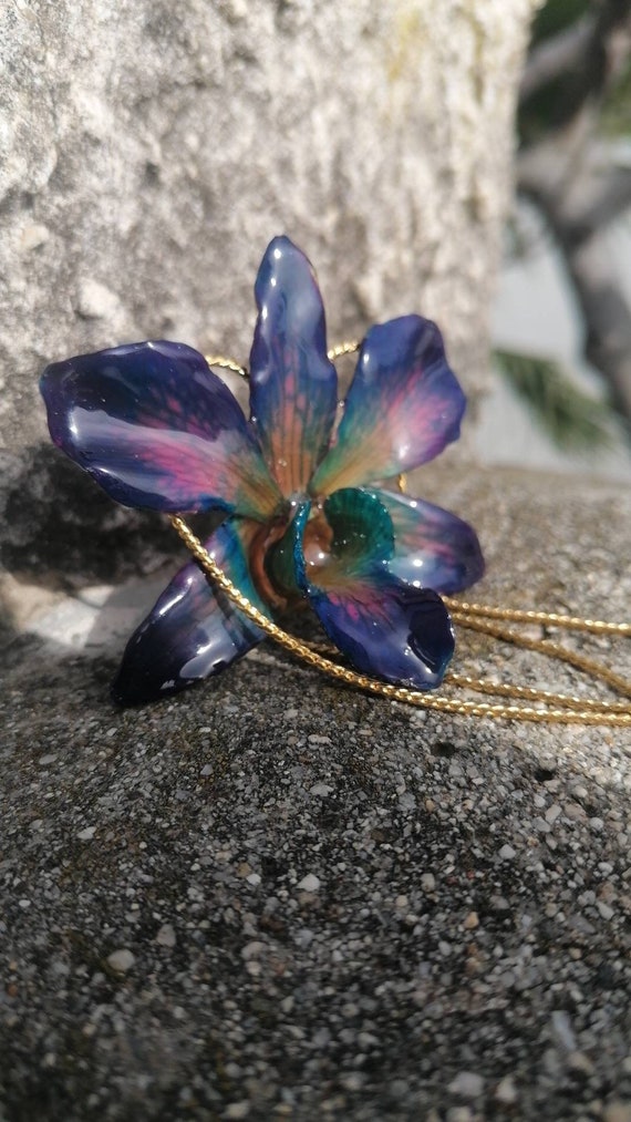 Uniquely colored orchid necklace embedded in resin and adjustable gold-plated slider