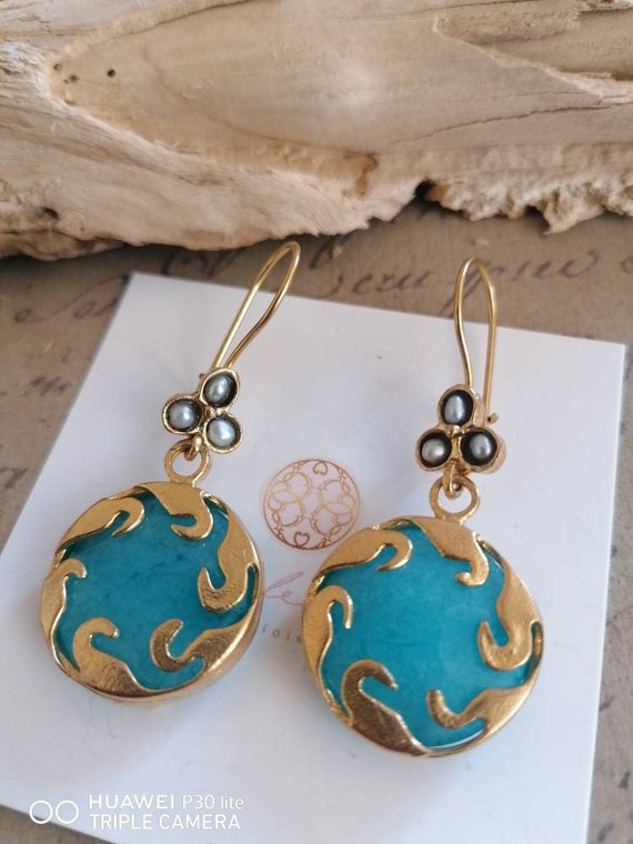 Earrings in matt gold on bronze and finished with natural pearls and natural blue quartz