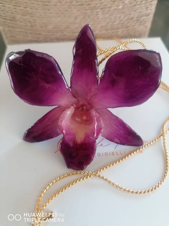 Natural Dendrobium orchid incorporated in resin with galvanized gold slider adjustable as desired