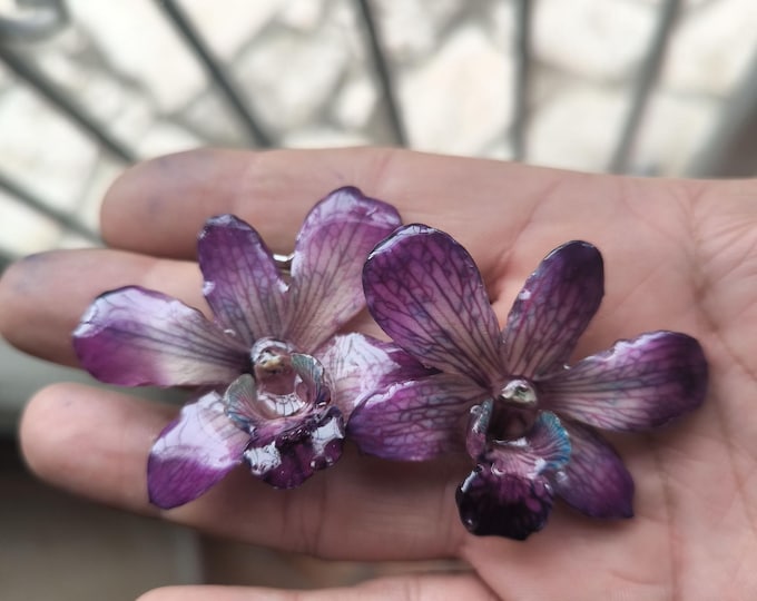 Pair of purple Dendrobium orchids with turquoise and green veins embedded in resin with silver hooks