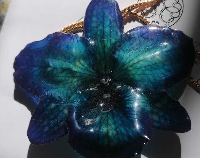 Natural blue orchid incorporated in resin with galvanized gold ups and downs