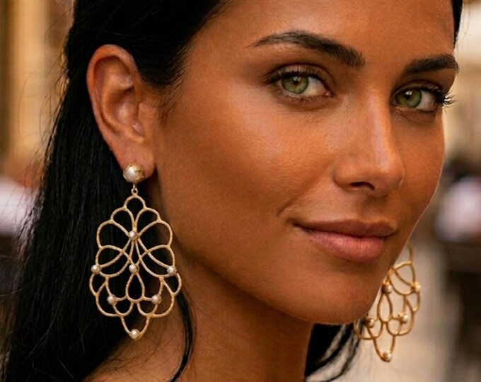 Earrings in matte gold on bronze and finished with natural pearls.