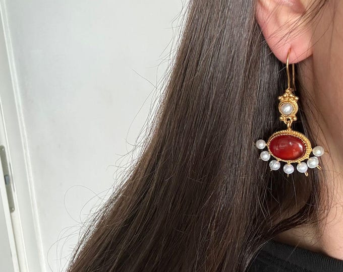 Earrings in matte gold on bronze and finished with natural pearls and carnelians of the highest quality.