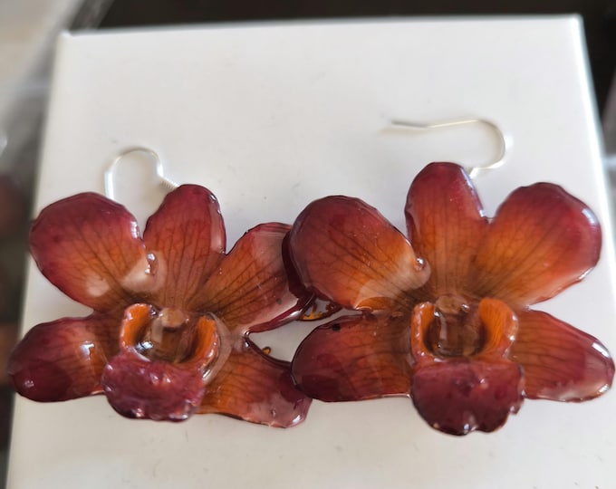 natural red orchid drop earrings embedded in resin with silver hook.